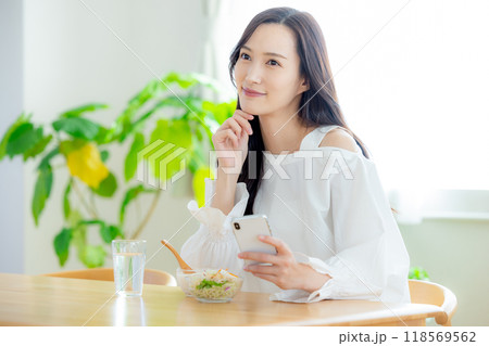 朝食の時にスマホを見る女性 118569562
