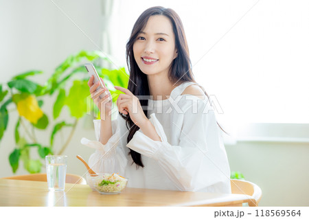 朝食の時にスマホを見る女性 118569564