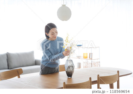 花瓶に花を挿す女性 118569654