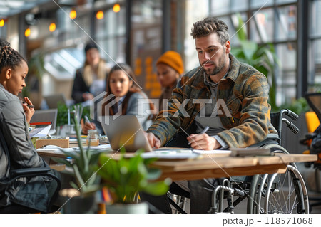Inclusive office environment with man in wheelchair working collaboratively Inclusive office environment with man in wheelchair working collaboratively 118571068