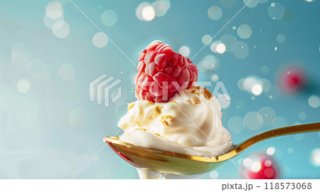 Golden spoon filled with creamy yoghurt and topped with fresh raspberries Golden spoon filled with creamy yoghurt and topped with fresh raspberries 118573068