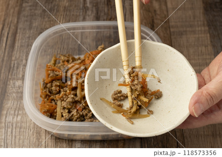 きんぴらごぼう 菜箸できんぴらごぼうを盛り付ける 118573356