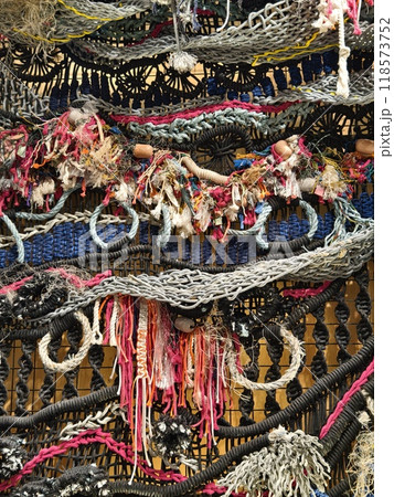 A ropes piece of art is displayed on a wooden wall A ropes piece of art is displayed on a wooden wall 118573752