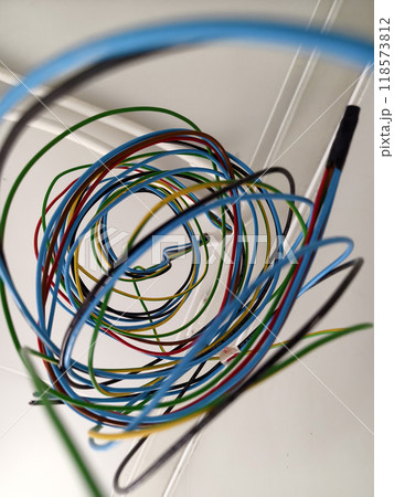 A collection of various wires is hanging down from the ceiling 118573812