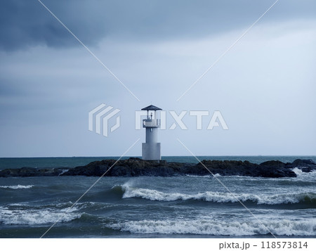 A solitary lighthouse stands in the ocean 118573814