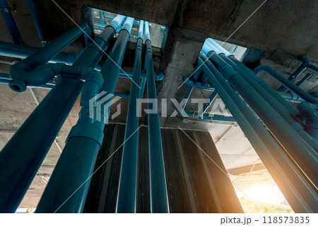 A large building currently under construction that has many blue pipes 118573835