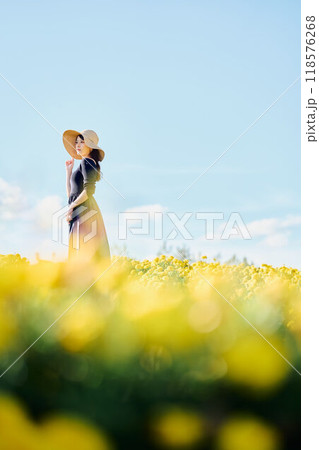 花畑で帽子をかぶって立つ女性 118576268