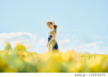 花畑で帽子をかぶって立つ女性 花畑で帽子をかぶって立つ女性 118576270