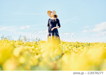 花畑で帽子をかぶって立つ女性 118576277