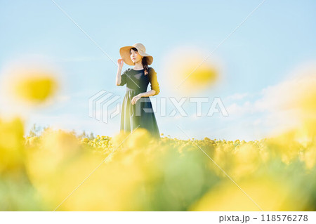 花畑で帽子をかぶって立つ女性 118576278