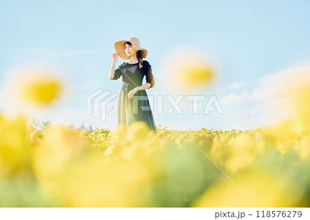 花畑で帽子をかぶって立つ女性 118576279