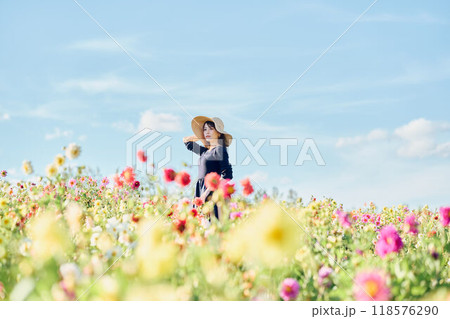 花畑で帽子をかぶって立つ女性 118576290