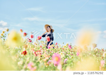 花畑で帽子をかぶって立つ女性 118576292