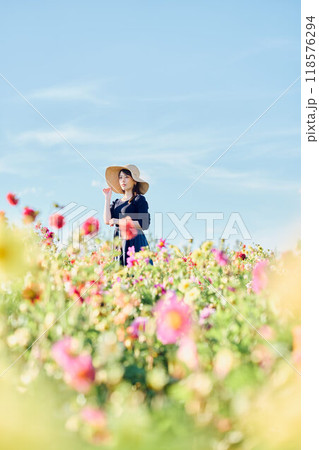 花畑で帽子をかぶって立つ女性 花畑で帽子をかぶって立つ女性 118576294