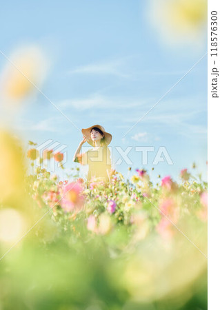 花畑で帽子をかぶって立つ女性 118576300
