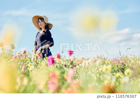 花畑で帽子をかぶって立つ女性 花畑で帽子をかぶって立つ女性 118576307