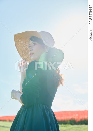 花畑で帽子をかぶって立つ女性 118576446