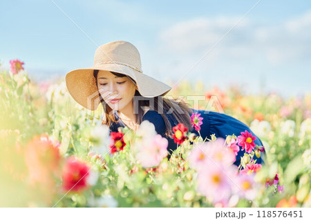 花畑で帽子をかぶって立つ女性 118576451