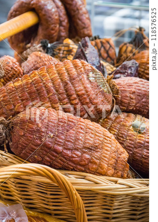 Fresh prepared smoked hams with spices in wicker basket on market stall Fresh prepared smoked hams with spices in wicker basket on market stall 118576525