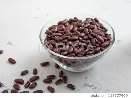 Dry raw organic purple beans in glass bowl on light table.Macro. Dry raw organic purple beans in glass bowl on light table.Macro. 118577409