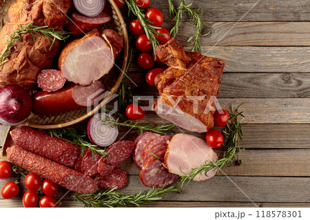 Food tray with delicious salami, ham, fresh sausages, tomato, and rosemary. Food tray with delicious salami, ham, fresh sausages, tomato, and rosemary. 118578301