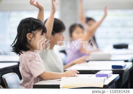 授業を受ける小学生 ハイと手を挙げ挙手をする 118581426