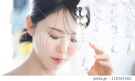 美容やビューティーに　輝く美しい肌ででアンニュイな表情の色っぽい(艶っぽい)女性　目を閉じて俯く	 118581562