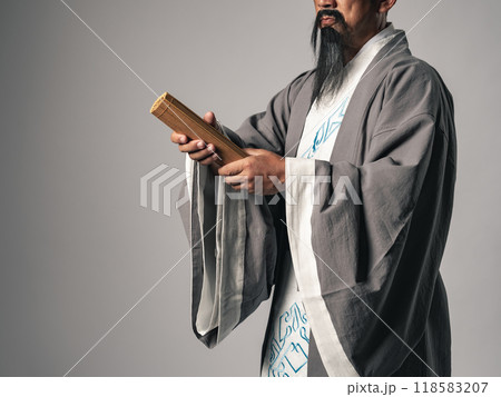 三国志に登場する諸葛孔明のような中国歴史上の人物が竹簡を差し出しているシーン 118583207
