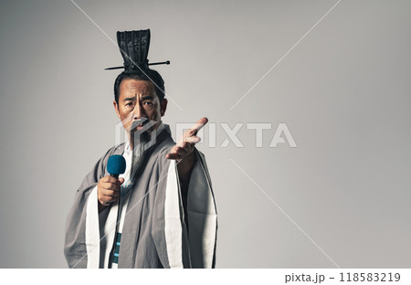 三国志に登場する諸葛孔明のような中国歴史上の人物がマイクを持って演説するシーン 118583219