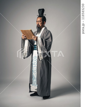 三国志に登場する諸葛孔明のような中国歴史上の人物が竹簡に書かれた文字を読むシーン 三国志に登場する諸葛孔明のような中国歴史上の人物が竹簡に書かれた文字を読むシーン 118583230