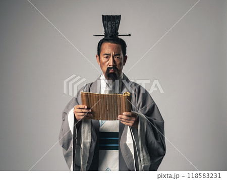三国志に登場する諸葛孔明のような中国歴史上の人物が竹簡に書かれた文字を読むシーン 118583231
