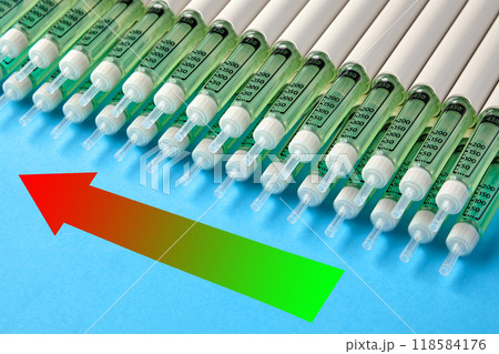 Rows of insulin syringes pens and an upward arrow on a blue background. The rise of diabetes cases Rows of insulin syringes pens and an upward arrow on a blue background. The rise of diabetes cases 118584176