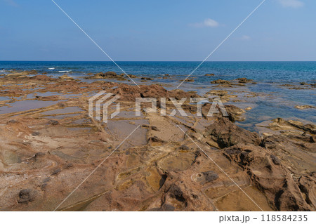 Rocky Coastal Terrain with Shallow Tide Pools on a Clear Day Rocky Coastal Terrain with Shallow Tide Pools on a Clear Day 118584235