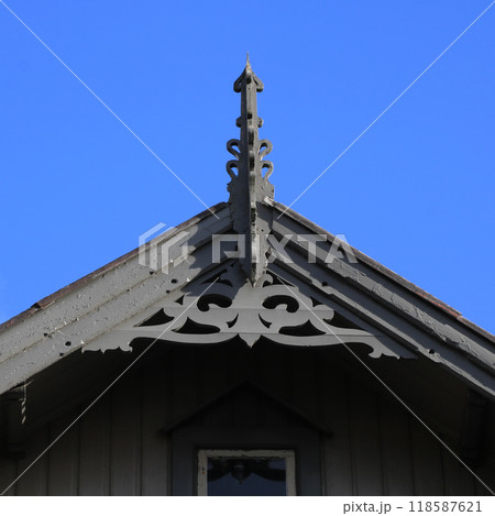 Grey gable of a old timber house in Egersund with beautiful ornaments. Grey gable of a old timber house in Egersund with beautiful ornaments. 118587621
