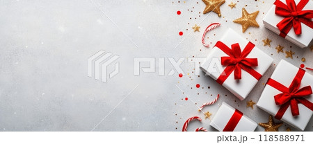 White gift boxes with red ribbons and candy canes on a light surface 118588971