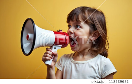 A little girl is joyfully holding a megaphone with her mouth wide open 118589681