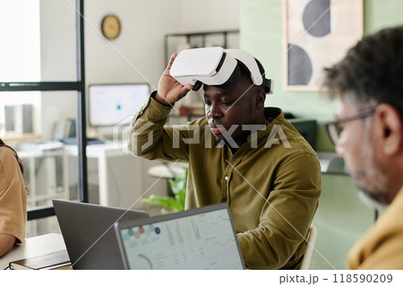 Man Using Virtual Reality Headset in Office Setting Man Using Virtual Reality Headset in Office Setting 118590209
