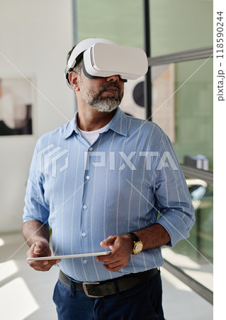 Experiencing Virtual Reality Wearing VR Headset in Office Experiencing Virtual Reality Wearing VR Headset in Office 118590244
