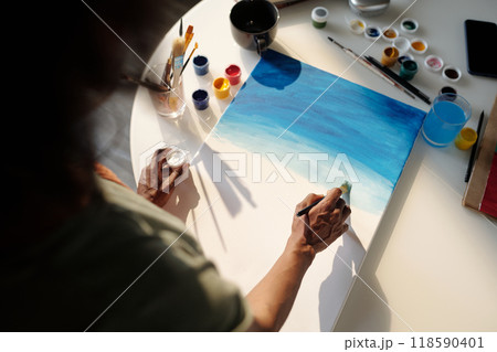 Painting Artwork with Blue Watercolors on Canvas 118590401