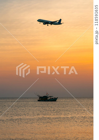Passenger plane is landing over the sea and a floating fishing ship 118591635