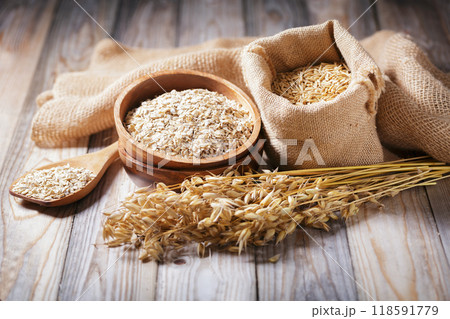 grains of oats, oatmeal and oats spikelets on wooden background 118591779