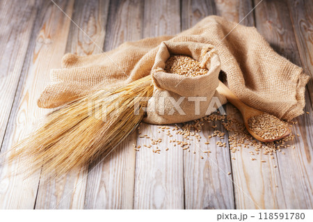 Barley grains and spikelets of barley on wooden background Barley grains and spikelets of barley on wooden background 118591780