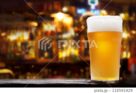 Glass of beer in a bar on wooden desk 118591929