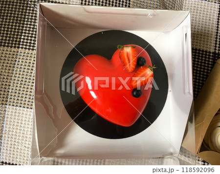 Red cake with strawberries in the shape of a heart top view. St. Valentine's Day sweets and gift Red cake with strawberries in the shape of a heart top view. St. Valentine's Day sweets and gift 118592096