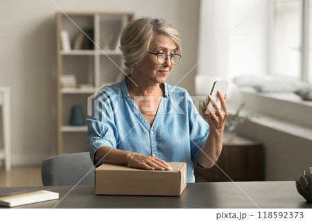 Woman calls a courier to pick up a prepared parcel Woman calls a courier to pick up a prepared parcel 118592373