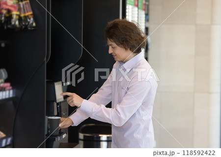 Positive young consumer man buying coffee at vendor shop 118592422