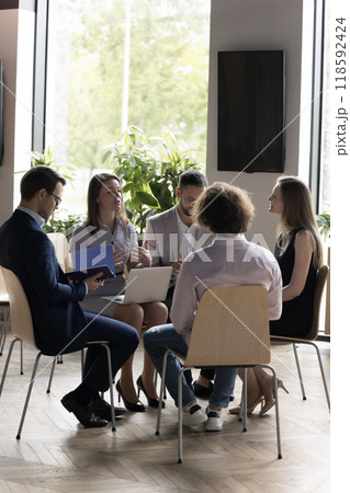 Business team sitting on chairs in circle, talking, brainstorming 118592424