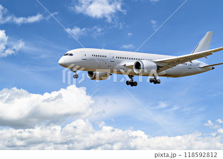Passenger plane landing at the airport, under a blue sky with white clouds Passenger plane landing at the airport, under a blue sky with white clouds 118592812