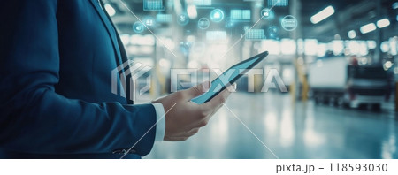 Businessman in a blue suit using an iPad in a modern office corridor with digital data flow and futuristic technology concept. 118593030