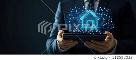 Businessman holding a tablet with a futuristic smart home hologram interface in dim light environment 118593032